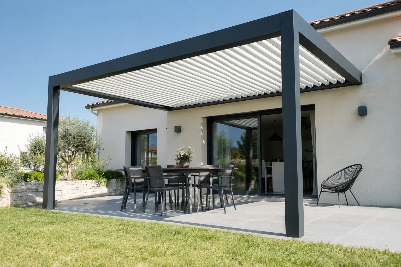 Pergola bioclimatique en aluminium installée sur la terrasse d'une maison