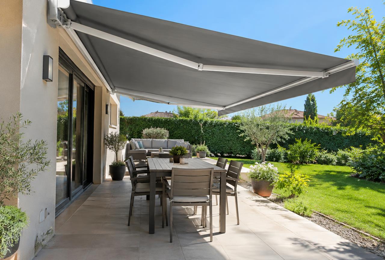 Store banne gris déployé au-dessus d'une terrasse ensoleillée